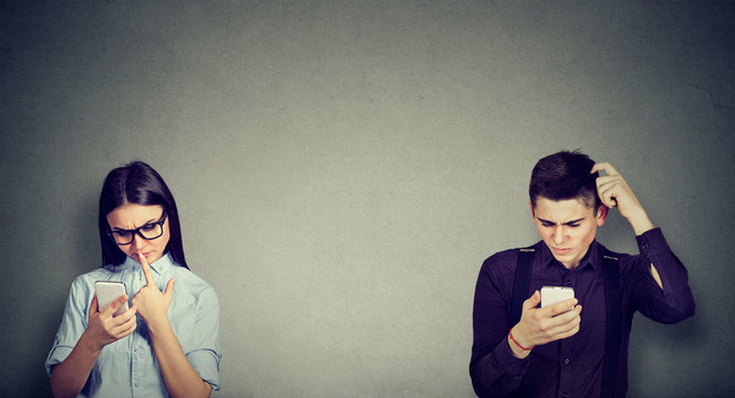 Perplexed man and woman looking at mobile phone