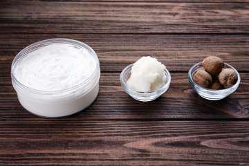 Shea butter, nuts and cream on wooden table