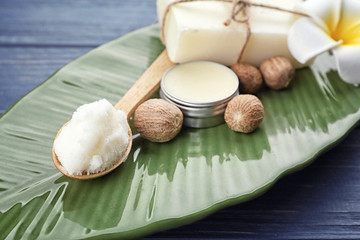 Different cosmetic products with shea butter on plate, closeup