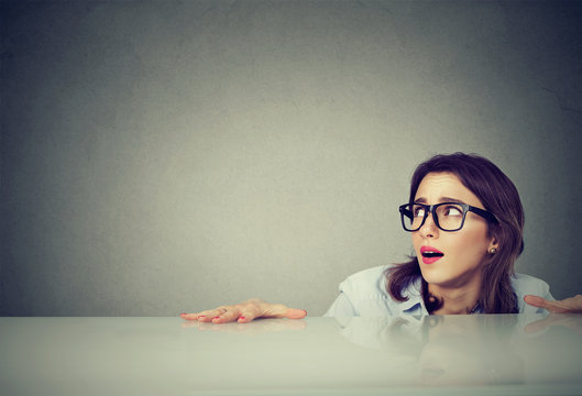 Anxious Young Woman Hiding Peeking From Under The Table