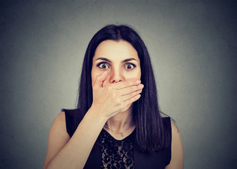 Concerned scared young woman with hand on mouth