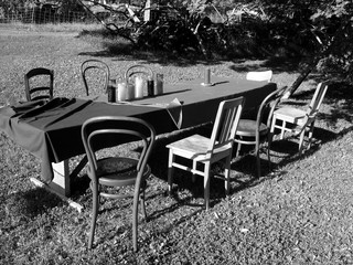 Schöne alte Holzstühle an der improvisierten Tafel draußen auf der Wiese auf dem Bauernhof in...