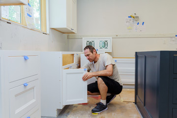 worker installing kitchen cupboard