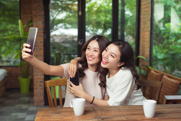 Asian woman friends hugging and make selfie photo together