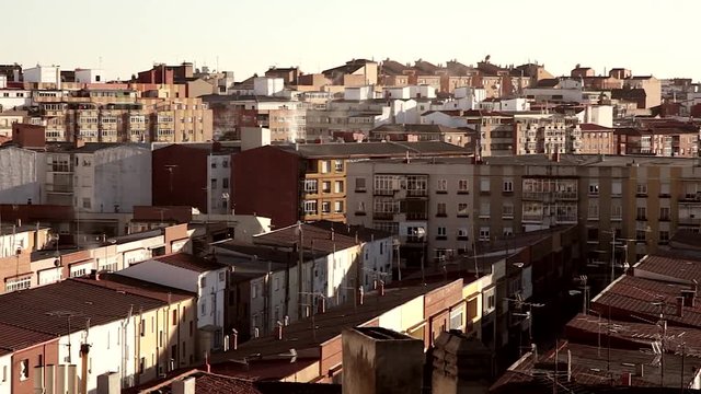 Azoteas, tejados y edificios a distintos niveles de una ciudad, con chimeneas echando humo y antenas de television en los tejados