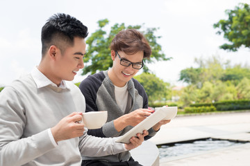 Two cheerful asian business people discussing with documents