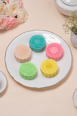 Sweet color of snow skin mooncake. Traditional mid autumn festival foods with tea on table setting.