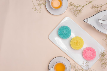 Obraz na płótnie Canvas Sweet color of snow skin mooncake. Traditional mid autumn festival foods with tea on table setting.