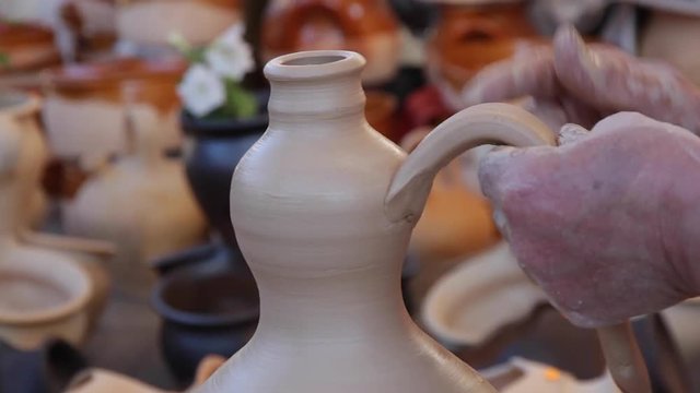 Alfarera acabando una vasija de barro y colocando el asa en Cer&aacute;mica Tradicional ( 2 Cortes ) 