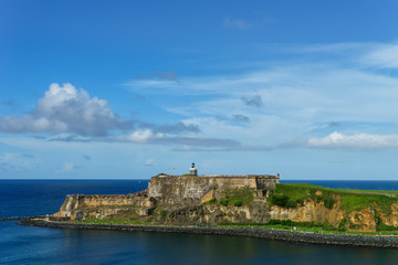 Fototapeta na wymiar Scenic view of historic colorful Puerto Rico city in distance with fort in foreground from the sea (cruise ship)
