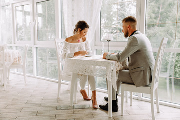 Flirting in a cafe. Beautiful loving couple sitting in a cafe enjoying in coffee and conversation