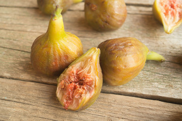Ripe green and brown figs on the grey wooden table