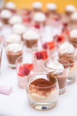 Tavolo buffet con bicchierini di dolci al cucchiaio in una cerimonia 