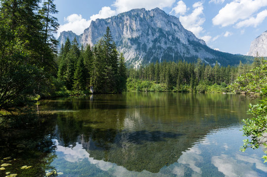 Mountain reflecting in the crystal clear waters of an alpine lake © Emil