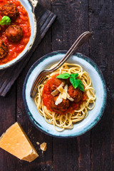 Pasta with meatballs and tomato sauce and cheese, top view, rustic style