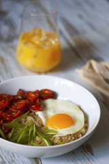 Savory quinoa with broiled tomatoes, green onions and sunny side up egg