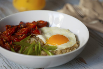 Savory quinoa with broiled tomatoes, green onions and sunny side up egg