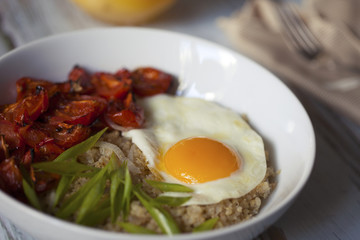 Savory quinoa with broiled tomatoes, green onions and sunny side up egg