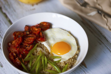 Savory quinoa with broiled tomatoes, green onions and sunny side up egg