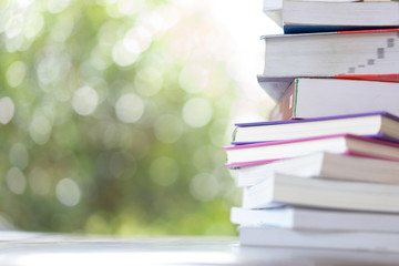 stack of books with green bokeh background