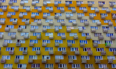Flats in a block. 
Apartment block from the outside with lots of windows and balconies.