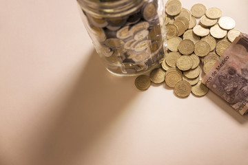 mexican pesos banknotes and coins in glass jar