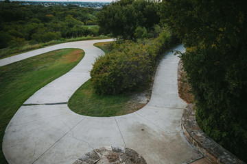 There is concrete path in the summer park