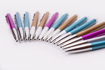 Closeup of colorful pens in half circle on the white background
