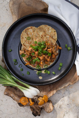 Pilzragout mit Serviettenknödel auf schwarzem Teller