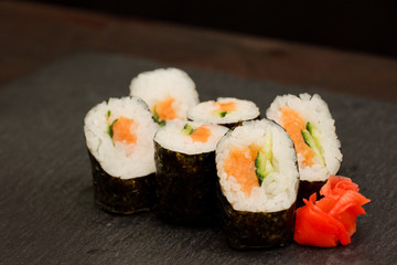 Fresh traditional Japanese food -rolls with salmon, ginger  served on black stone