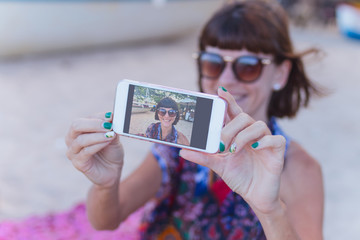 Beautiful young woman doing selfie on the beach of tropical Bali island, Indonesia.