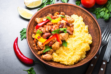 Corn porridge and meat with vegetables and beans in tomato.