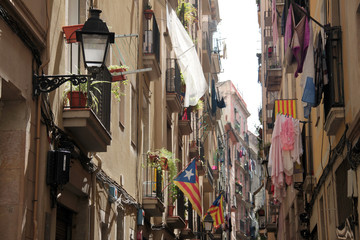 Fototapeta na wymiar Barcelona, May 2015; Balconies and windows with flags and clothes hanging out