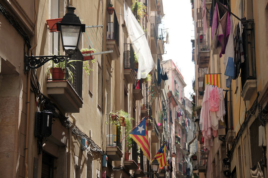 Barcelona, May 2015;  Balconies and windows with flags and clothes hanging out