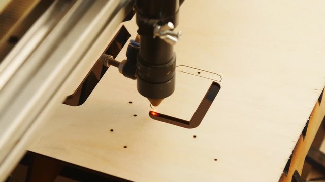 Laser torch cuts a wooden board