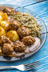 Homemade fried meatballs served with potatoes and cabbage.