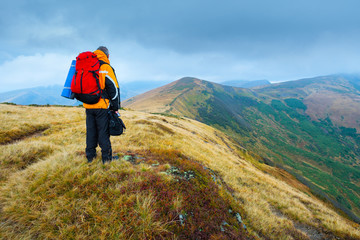 Obraz premium Hiking tourists with backpacks in the mountains. Climb to the top mountains. Concept theme: nature, weather, mountain climbing, tourism, extreme, healthy lifestyle, adventures. Unrecognizable faces.