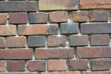 Old red brick wall with crushed mortar
