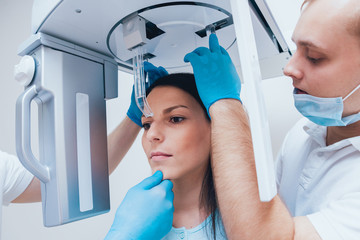 Young woman patient standing in x-ray machine.