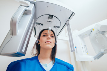 Young woman patient standing in x-ray machine.