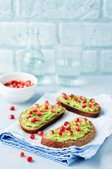 Smashed avocado pomegranate rye sandwiches