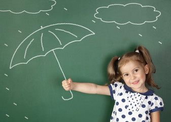 child girl hold umbrella near school blackboard, weather concept