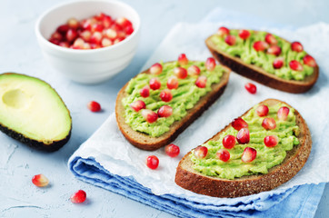 Smashed avocado pomegranate rye sandwiches