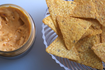 Cheese chilli dip with nachos in a bowl on a table in the kitchen