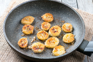 Caramelized bananas in a frying pan on wooden table