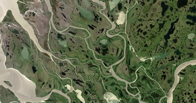 Very high-altitude overflight aerial of the Mackenzie River delta at the Beaufort Sea. Clip loops and is reversible. Elements of this image furnished by USGS/NASA Landsat