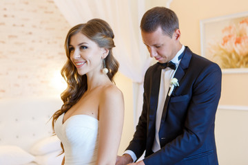 The groom ties the laces on the bride
