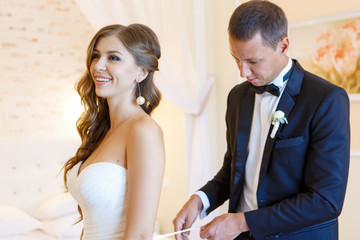 The groom ties the laces on the bride
