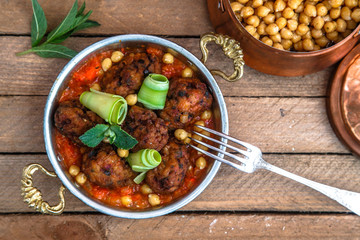 Arabian meatballs kofte with chickpeas, spicy tomato sauce and mint