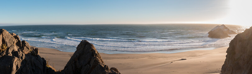 Panoramic View of Ocean Waves on Smooth West Coast Beach with Rocks in the Foreground